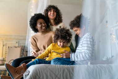 Mutlu çok ırklı aile evde birlikte vakit geçiriyor. Eşcinsel çift çocukları mutluluk kavramını sever