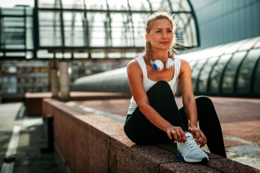 Güzel, formda bir kadın dışarıda egzersiz yapmaya hazırlanıyor. Spor insanları sağlıklı yaşam tarzı koşma konsepti