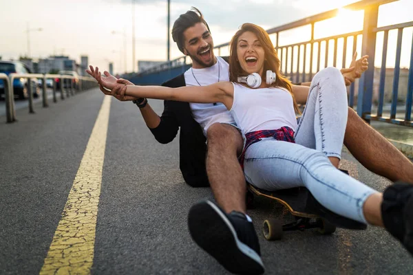 幸せなカップルがスケートボードに乗ってアウトドアを楽しんでいるの肖像画 10代の幸福の概念 — ストック写真