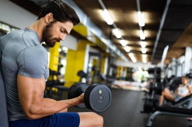 Spor salonunda çalışan formda bir gencin portresi. Spor insanları sağlıklı yaşam tarzı egzersizi konsepti