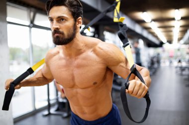 Genç kaslı vücut geliştirici yakışıklı adam spor salonunda egzersiz yapıyor. Spor insanları spor konsepti