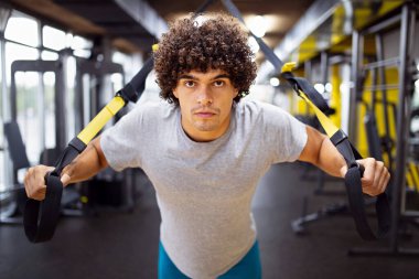 Genç kaslı vücut geliştirici yakışıklı adam spor salonunda egzersiz yapıyor. Spor insanları spor konsepti