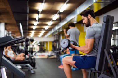 Spor salonunda çalışan formda bir gencin portresi. Spor insanları sağlıklı yaşam tarzı egzersizi konsepti