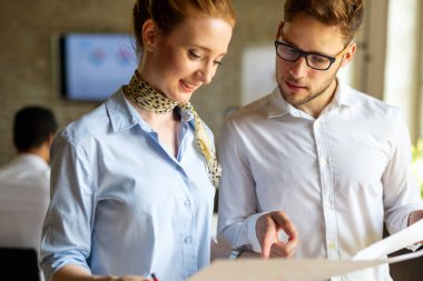 Birlikte yeni bir proje üzerinde çalışıyoruz. Çok ırklı iş adamlarından oluşan mutlu bir grup ofiste bir takım olarak işbirliği yapıyor.