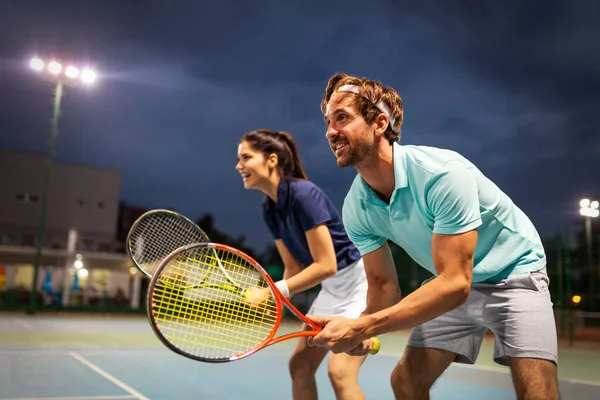 这对年轻漂亮的夫妇正在室外网球场上作为一个团队打网球 人民体育概念 — 图库照片