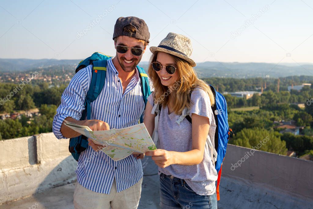 Happy young tourist couple, friends sightseeing city with map. Travel people vacation concept