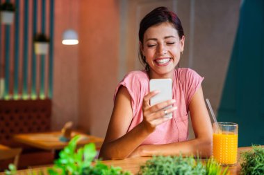 Akıllı telefon kullanan mutlu genç bir kadının portresi. İnsanlar cep telefonu bağlantısı çalışma kavramı