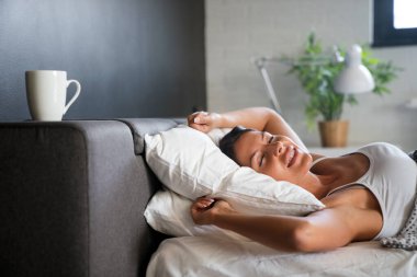 Genç, güzel, mutlu bir kadın sabah dinlenmiş bir şekilde uyanır.