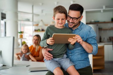 E- öğrenim için dijital tablet kullanan baba ve çocuğun portresi. Eğitimde evde eğitim veren dijital cihaz çocuk kavramı.