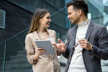 Dijital tablet kullanarak sosyal medya stratejisi üzerinde çalışan iki yaratıcı iş adamı. İş adamları konsept çalışır