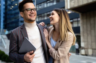 Başarılı genç iş adamları, tasarımcılar konuşuyor, modern iş binası önünde birlikte çalışıyorlar.
