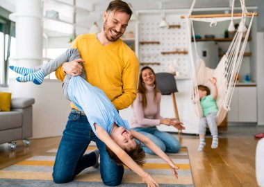Evde oynayan ve sarılan çocuklu mutlu bir aile. Mutluluk, insanlar, ebeveynlik, çocukluk kavramı.