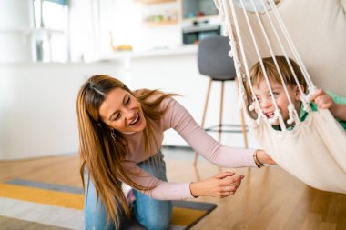 Güzel bir kadın ve küçük oğlu evde oynayıp eğleniyorlar. Mutlu aile kavramı