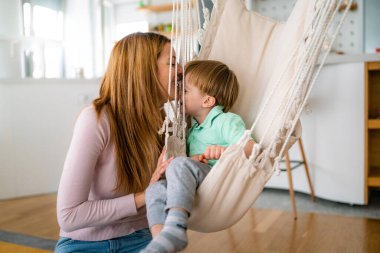 Güzel bir kadın ve küçük oğlu evde oynayıp eğleniyorlar. Mutlu aile kavramı