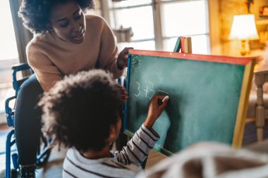 Küçük çocuk annesiyle ya da öğretmeniyle birlikte matematik egzersizleri yapıyor. Eğitim insanları eğlenceli konsept