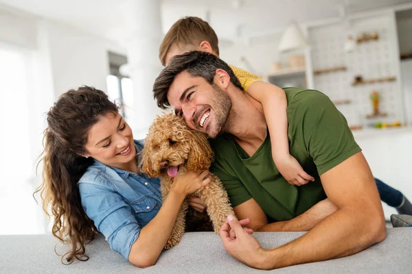Mutlu bir aile portresi ve evde birlikte eğlenen bir köpek. Mutlu aile kavramı, hayvanları sevmek, çocukluk.