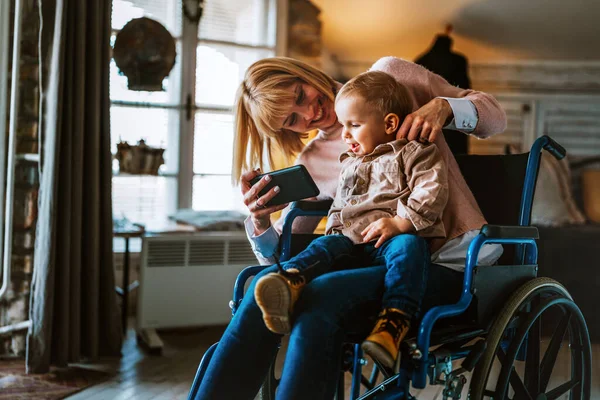 人々の技術家族の幸福の概念 自宅のデジタルタブレットを使って子供と一緒に車椅子で障害を持つ幸せな母親 — ストック写真