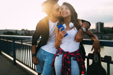 Şehirde uzun bir sörf tahtası sürerken eğlenen mutlu çiftin portresi. İnsanlar kaykay konsepti