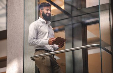 Ofisinde dijital tableti olan başarılı genç iş adamının portresi. İş adamları teknoloji çalışma kavramı