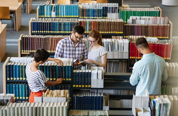 Bir Üniversite Kütüphanesinde Birlikte Çalışan Mutlu Bir Öğrenci Grubu Eğitim — Stok fotoğraf