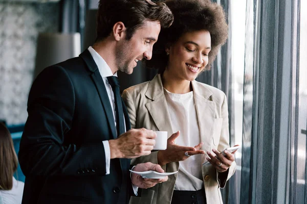 Genç ve mutlu iş adamları kahve molası sırasında sohbet ediyorlar.