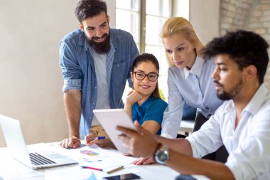 Birlikte çalışan ve ofiste gülümseyen yaratıcı iş adamlarının portresi. Başlangıçta çok ırklı iş adamları.