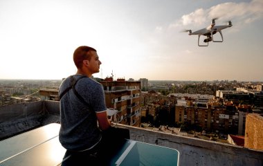 Uzaktan kumandalı insansız hava aracı uçuran genç teknisyen.