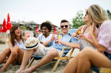 Plajda kokteyl içip yaz tatilinde eğlenen arkadaşlar. İnsanların mutluluk kavramı