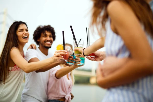 ビーチで楽しみながらカクテルを飲む幸せな若者たち — ストック写真