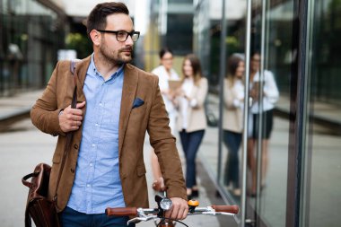 İşe gidiyorduk. Şehirde bisikletle gezen mutlu iş adamının portresi..