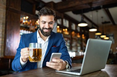 Kafede oturan başarılı bir girişimcinin portresi bir dizüstü bilgisayar üzerinde çalışıyor..