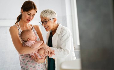 Mutlu çocuk doktoru bebeği muayene eder. Sağlık hizmetleri, insanlar, muayene konsepti