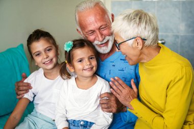 Torunlarını önemsemek, hastane koğuşunda geçirdiği tıbbi ameliyattan sonra dedesine sarılmak. Yaşlı adam klinik terapi sırasında yatakta dinleniyor. Sağlık hizmetleri desteği