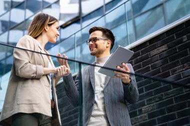 İş adamları, şehir planındaki işyerinde eğleniyor, çalışıyor ve sohbet ediyorlar.
