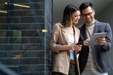 Dijital tablet kullanarak sosyal medya stratejisi üzerinde çalışan iki yaratıcı iş adamı. İş adamları konsept çalışır