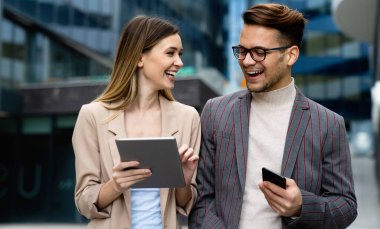 Dijital tablet kullanarak sosyal medya stratejisi üzerinde çalışan iki yaratıcı iş adamı. İş adamları konsept çalışır