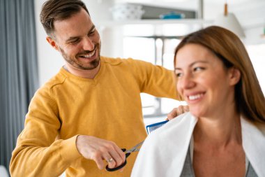 Karantina sırasında erkek kadının saçını kesiyor. Yalnızlık, çift, saç kesimi konsepti..