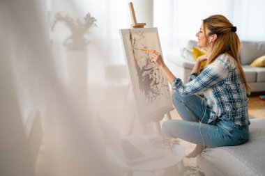 Evde resim yapan yaratıcı bir kadın. Coronavirus karantinası, izolasyon.