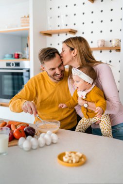 Mutfakta mutlu bir aile birlikte yemek pişiriyor. Evde sağlıklı yiyecekler..