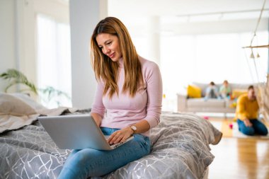 Evde dizüstü bilgisayar kullanan güzel bir genç kadın. Teknoloji konsepti