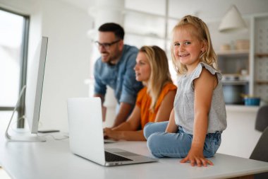 Evde bilgisayar başında çalışan mutlu bir aile babası ve çocuk. İş çevrimiçi iş yeri ev kavramı.