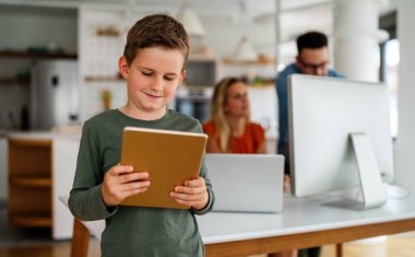 Evde eğitim sosyal mesafesi e-öğrenim online eğitim kavramı. Evde tablet kullanan mutlu okul çocuğu..