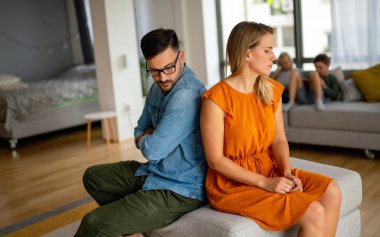 Sad pensive couple thinking of relationships problems sitting on sofa, conflicts in marriage, upset couple after fight dispute, making decision of breaking up get divorced clipart