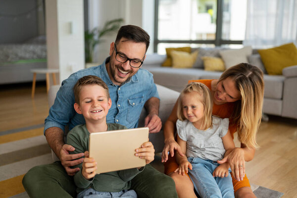 Digital device technology family online education concept. Happy young family with digital devices at home.