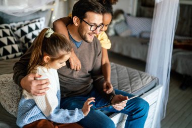 Mutlu bir aile. Baba ve çok ırklı çocuklar evdeki tablette oynuyorlar. Teknoloji, insanlar konsepti