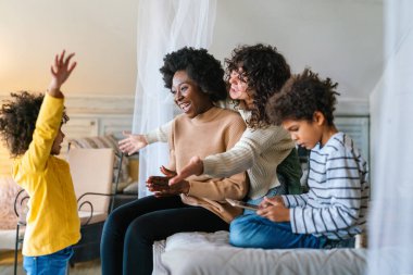 Mutlu çok ırklı aile evde birlikte vakit geçiriyor. Eşcinsel çift çocukları mutluluk kavramını sever