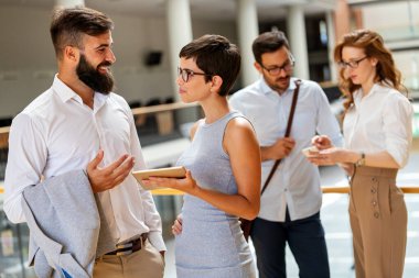 Genç iş adamlarından oluşan mutlu bir grup arkadaş toplantıda fikir alışverişinde bulunuyor. İş takım çalışması konsepti.