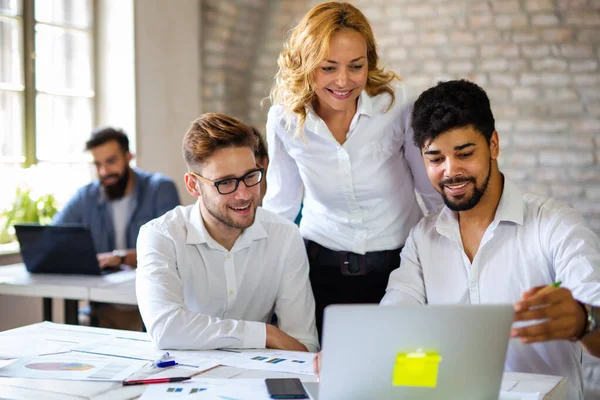 Çok ırklı iş adamlarından oluşan mutlu bir grup iş birliği yapıyor, şirket ofisinde toplantı üzerinde çalışıyorlar. Takım çalışması çeşitli iş konsepti