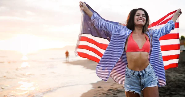 Mutlu kadın gülümseyip plajda koşarken bağımsızlık gününü kutluyor ve Amerika 'da özgürlüğün tadını çıkarıyor.