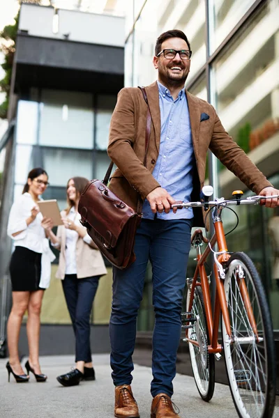 İşe gidiyorduk. Şehirde bisikletle gezen mutlu iş adamının portresi..